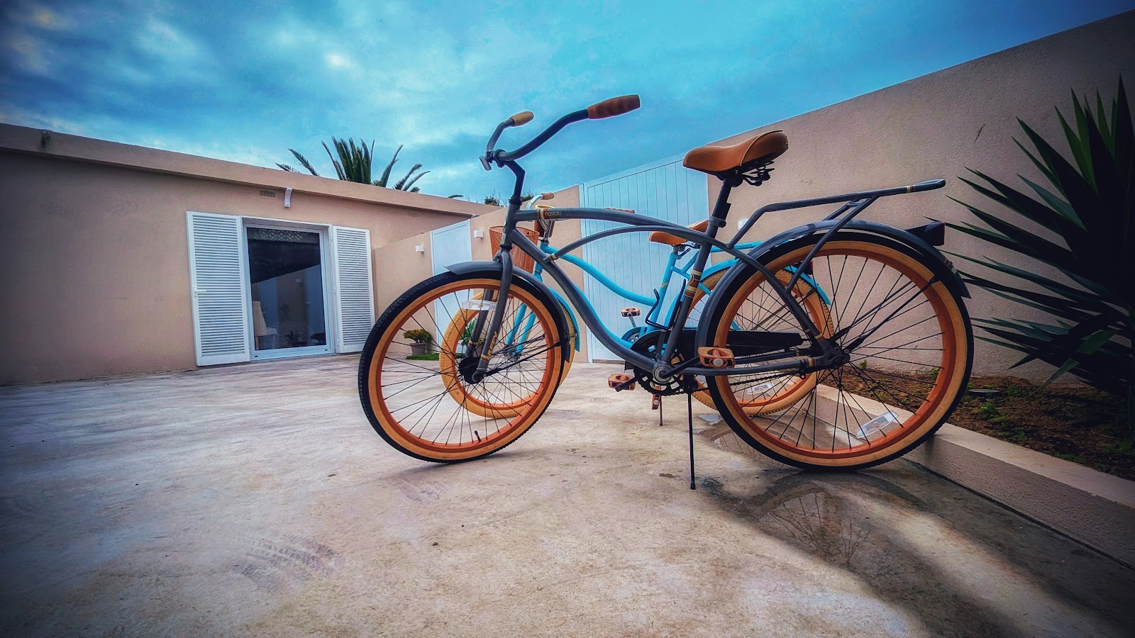 Bom Vizinho Guesthouse exterior patio with a blue bicycle